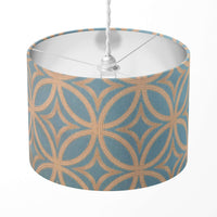 Turquoise blue and beige geometric print lampshade on a white background.