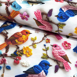 Colourful goldfinch bird and flower print upholstery curtain fabric in red, orange, pink, blue, brown and white.