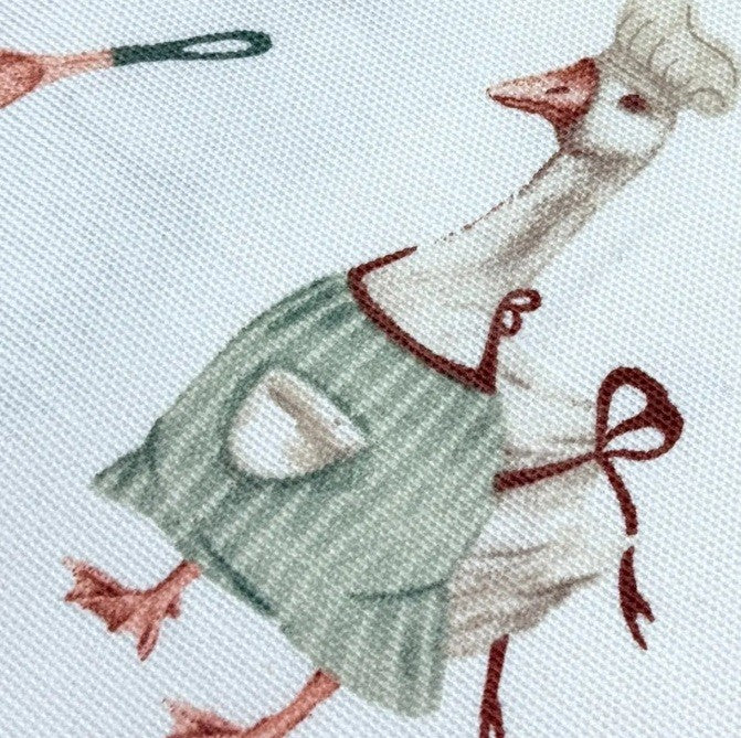 Goose print upholstery fabric in sage green, coral red  and white colours.