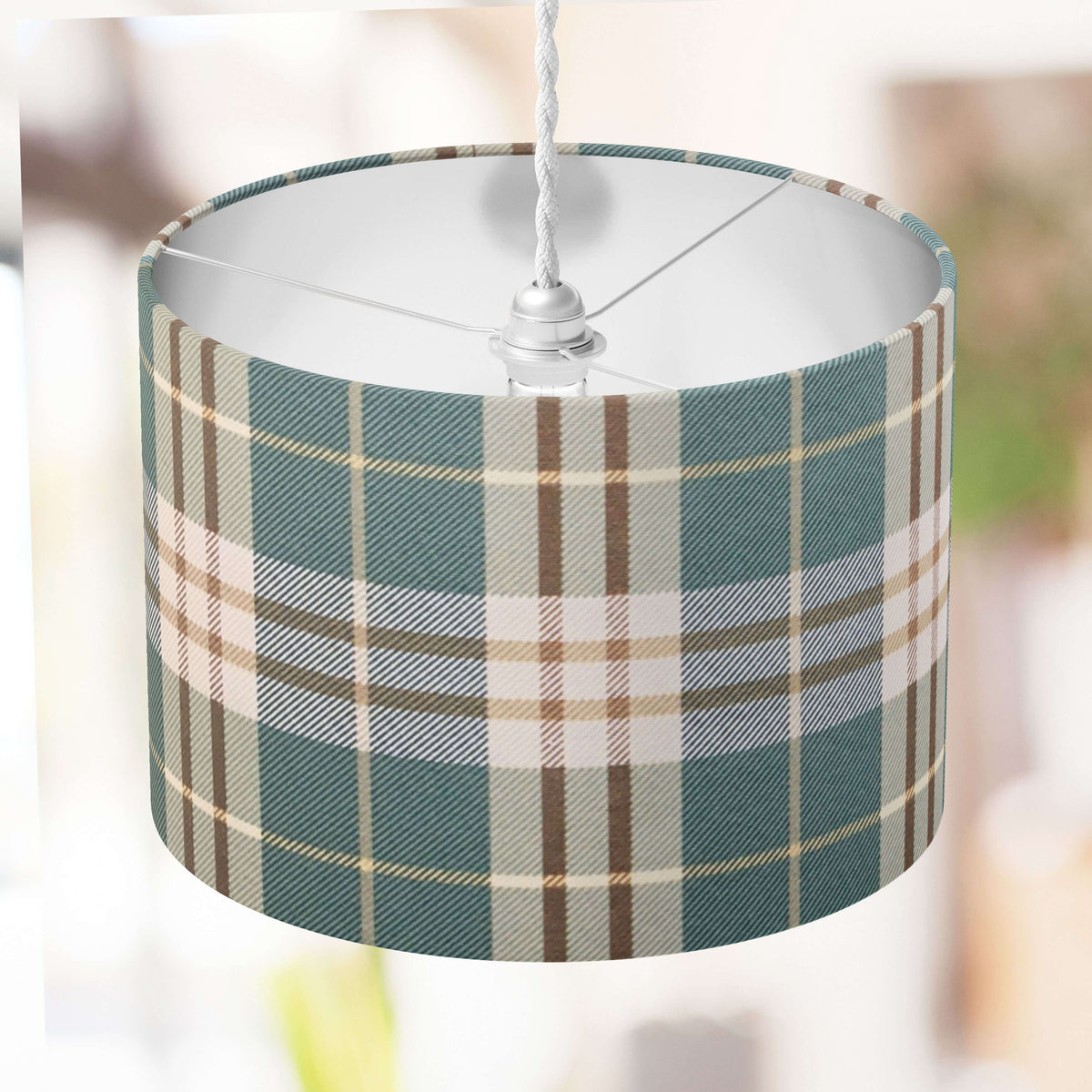 Green plaid patterned ceiling lampshade with a blurred background.
