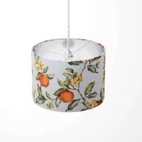 Floral and fruit patterned orange and green lampshade on a white background.
