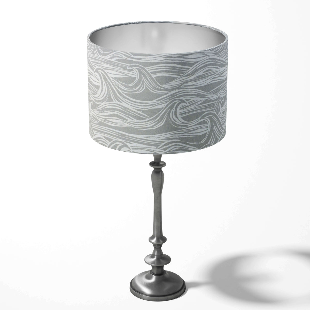Grey table drum lampshade with a coastal surf pattern on a white background.