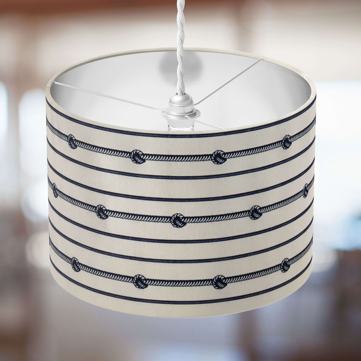 Striped marine ceiling lampshade with rope design on a blurred background.