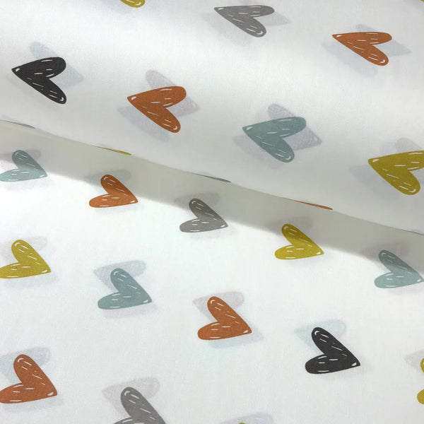 Colourful heart print cotton fabric featuring mustard yellow, rust orange, sage green and grey hearts on a white background.