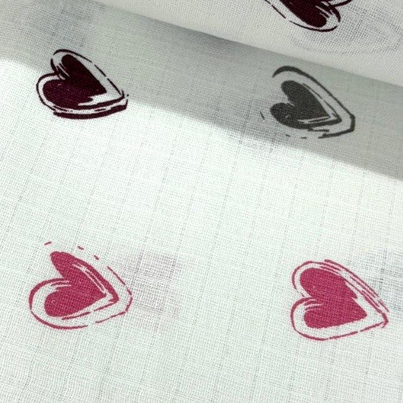Heart patterned 100% cotton muslin double gazue fabric on a white background.
