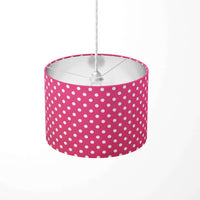 Fuchsia ceiling lampshade with white polka dots on a white background.