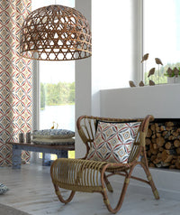 Rattan chair with geometric patterned cushion in a room with a large window and decorative elements.