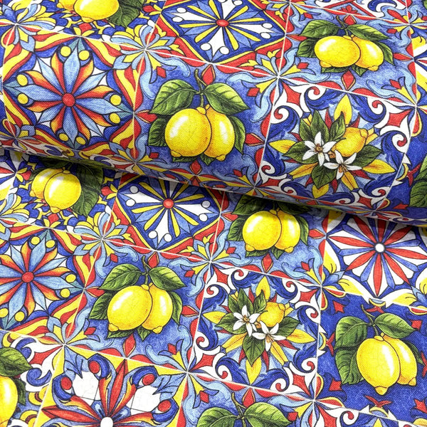 Colorful upholstery fabric with yellow lemons, red and blue tiles and floral patterns.