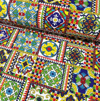 Colorful patterned upholstery fabric with geometric tile and floral designs.