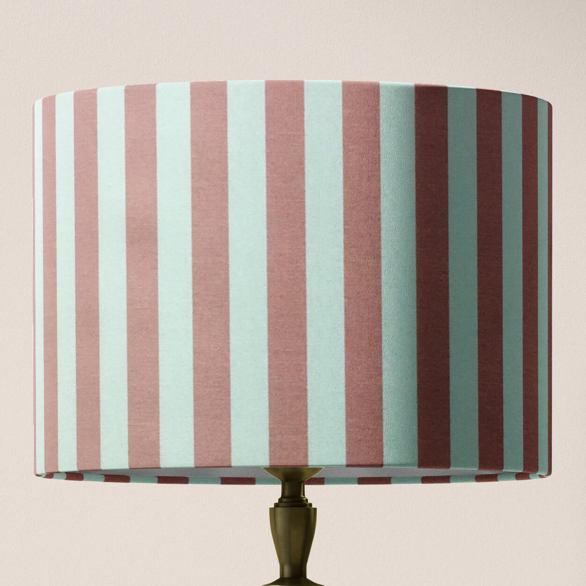 Striped lampshade with blush pink and white vertical stripes on a light pink background.