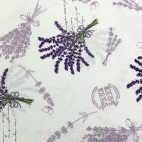 Cotton canvas upholstery fabric patterned with lavender flowers in lilac and purple on a white background.