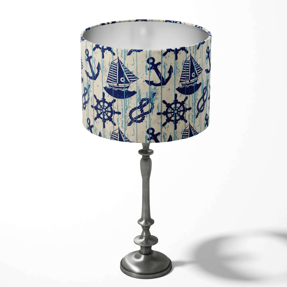 Blue and white table drum lampshade with a nautical coastal theme on a white background.