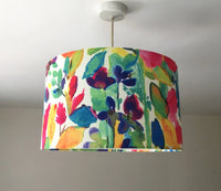 Ceiling lampshade with green leaves and purple pink yellow flowers printed on a white background.