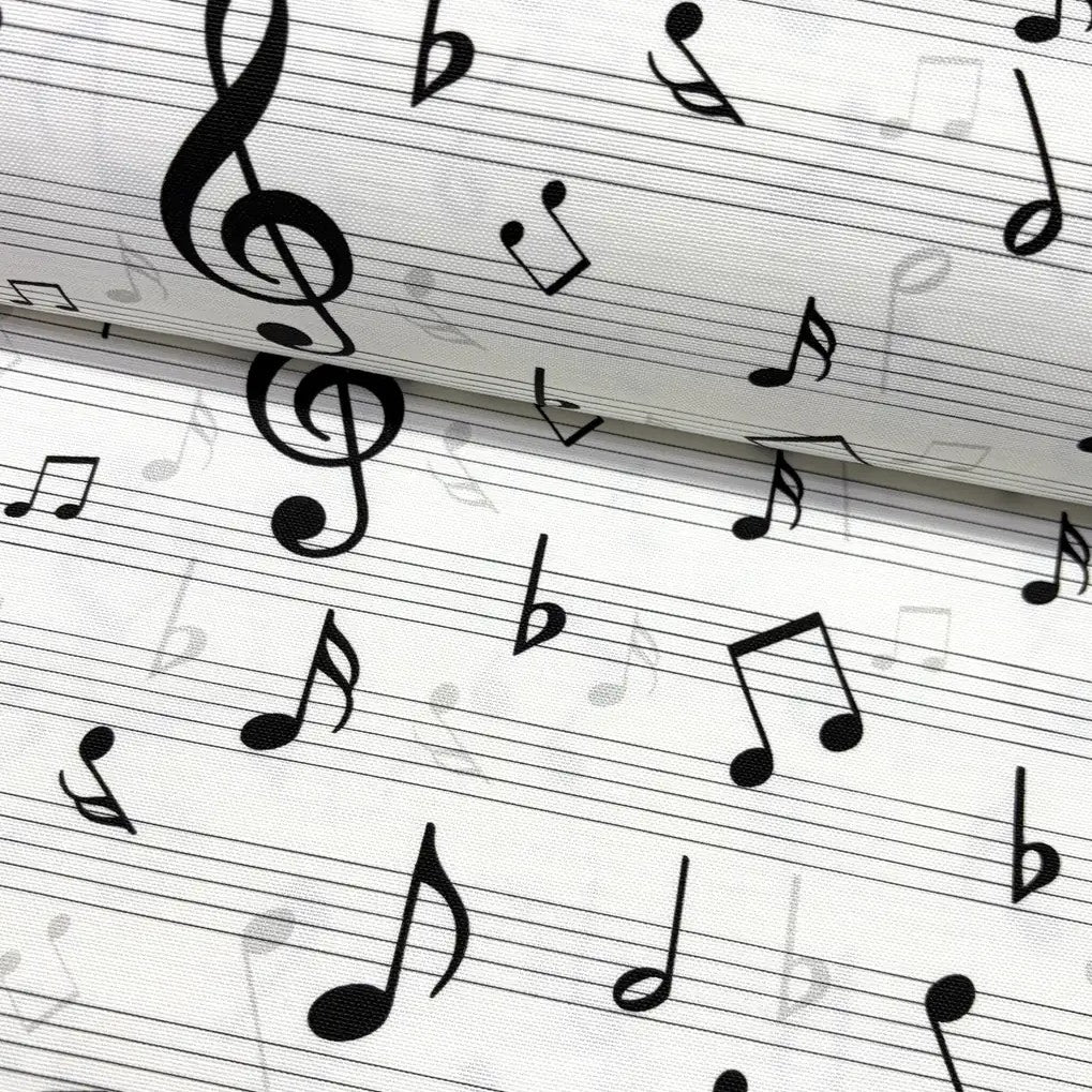 Close-up of black & white music notes patterned upholstery fabric.