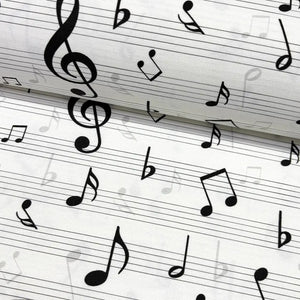 Close-up of black & white music notes patterned upholstery fabric.