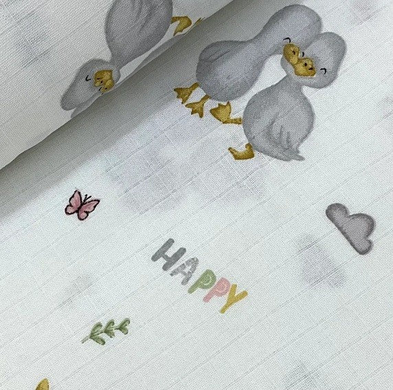 100% cotton muslin double gauze baby dressmaking fabric with grey ducks, butterfly, leaves, and the word 'HAPPY' on a white background.