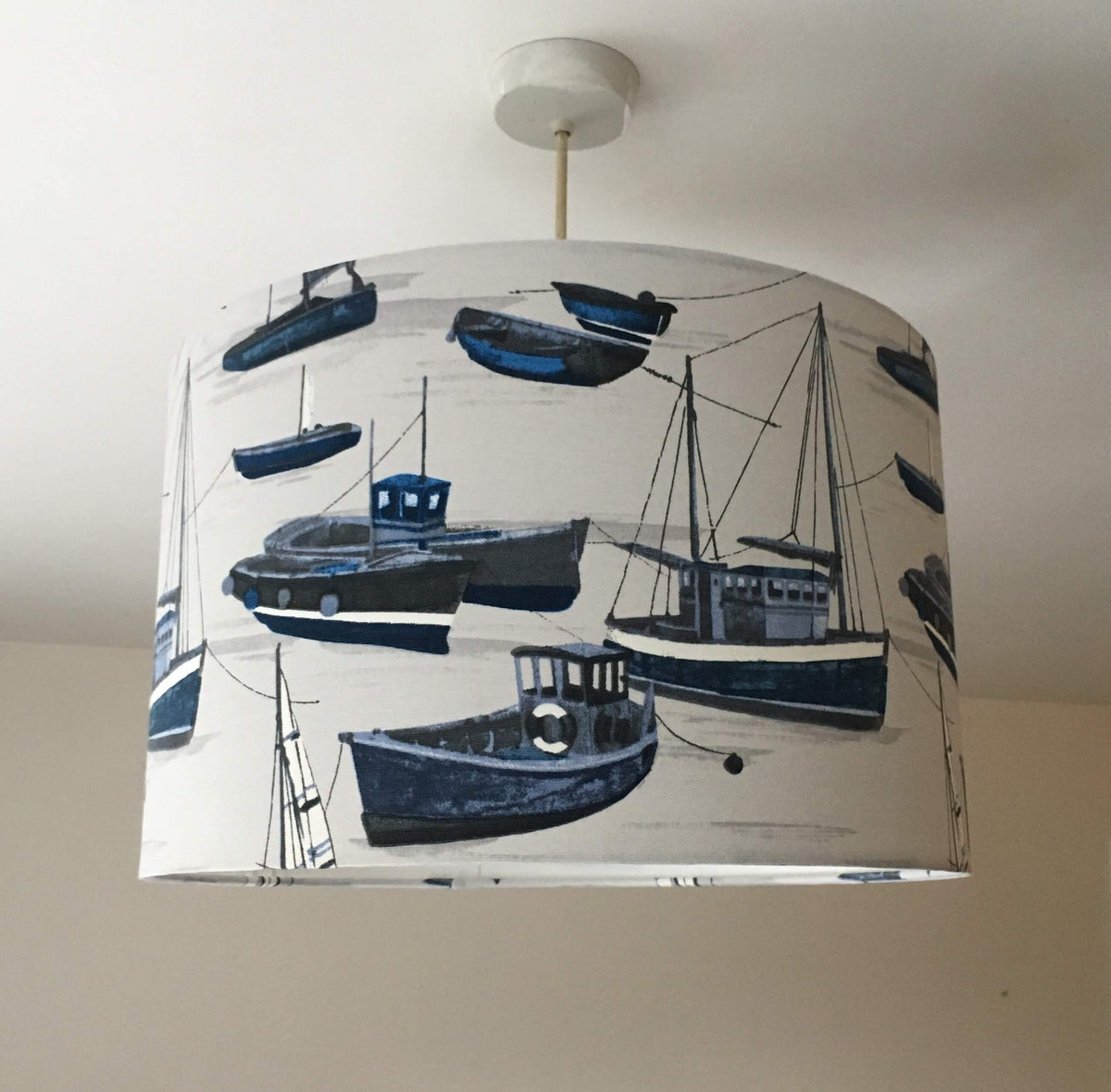 Navy blue, grey and white nautical boat lampshade hanging against a ceiling.