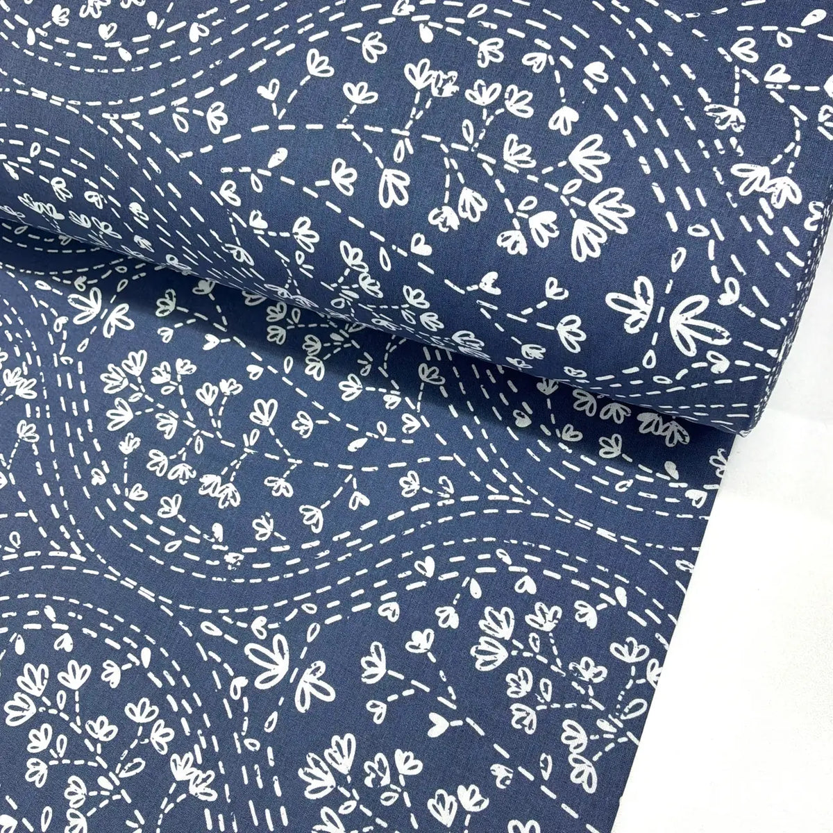 Navy blue floral vine fabric featuring a white floral vine and dotted trail print, ideal for quilting, dressmaking, patchwork, crafts and home décor.