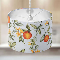 Lampshade with orange fruit and flowers and sage green leaves pattern on a neutral background.