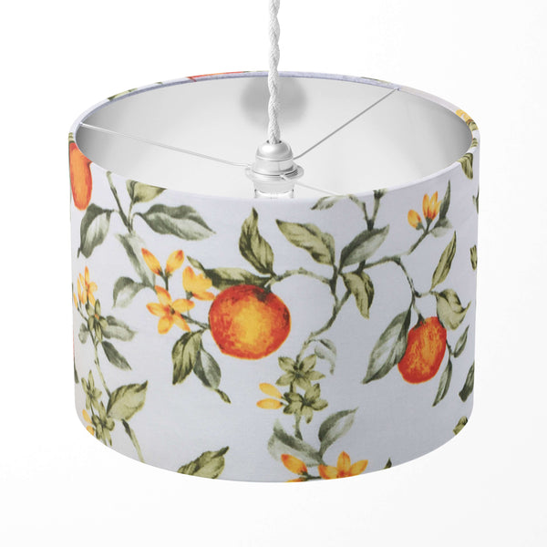 A drum lampshade with an orange fruit and green leaf print, designed for table lamps, floor lamps, or ceiling pendants.