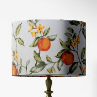 Lampshade with orange tree, sage green leaves and flowers pattern on a white background.