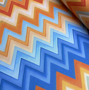 Close-up of upholstery curtain fabric with orange and blue chevron pattern.