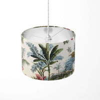 Tropical green palm leaf and tree patterned ceiling lampshade on a white background.