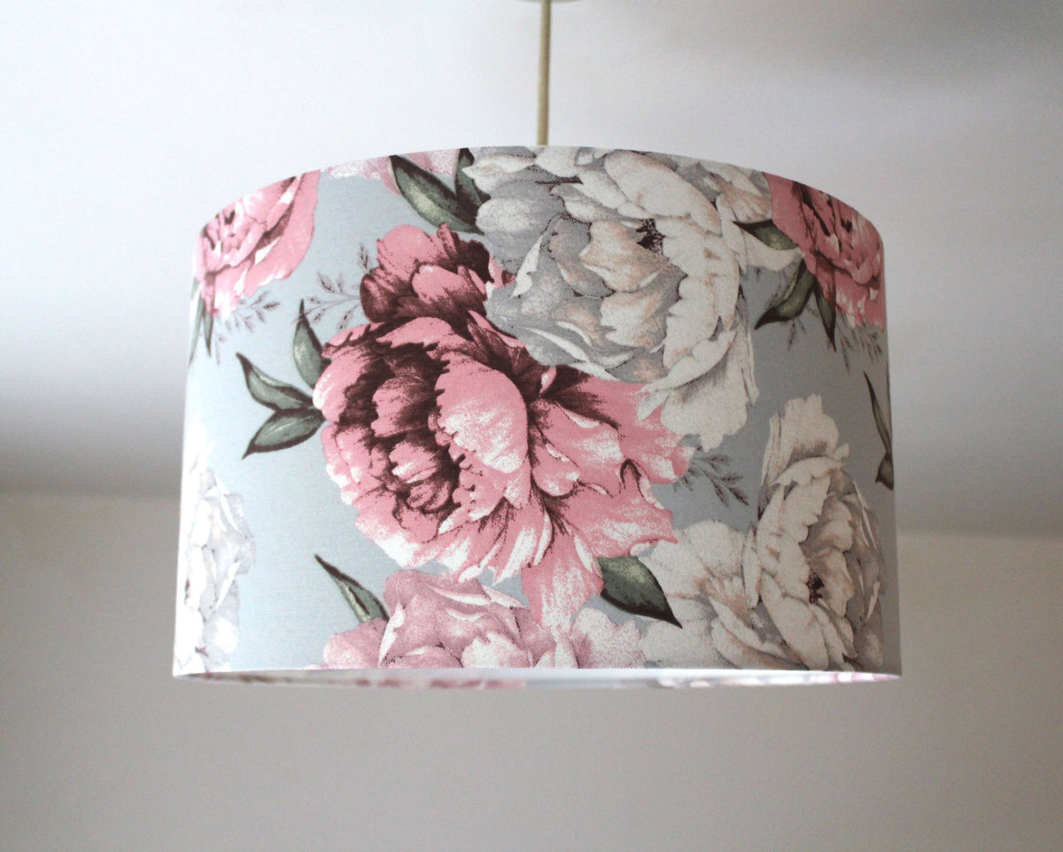 Pink and white floral patterned ceiling lampshade on a plain background.
