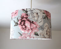 Pink and white floral patterned ceiling lampshade on a plain background.
