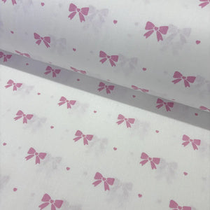 Cotton poplin fabric with pink bow pattern on a white background
