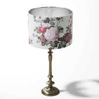 Pink flowers and sage green leaves patterned table lampshadeon on a white background.