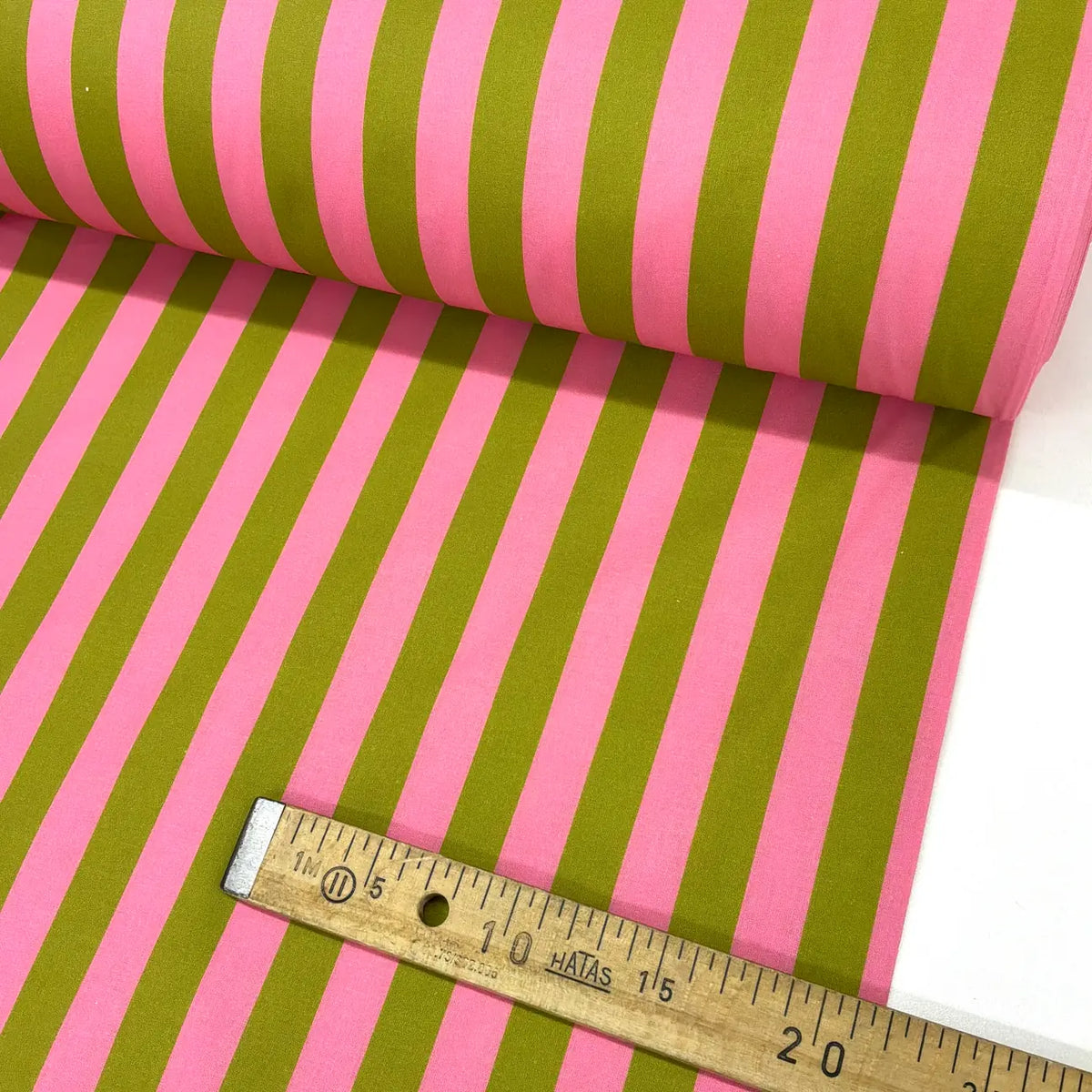 Roll of pink and green striped fabric with a ruler for scale.