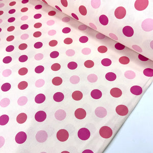 Pink polka dot cotton poplin fabric featuring fuchsia, dark pink and light pink spots on a white background.