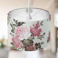 Retro blush pink flowers and sage green leaves patterned lampshade on a blurred background.