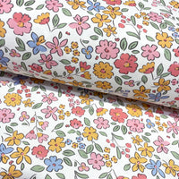 Floral fabric with pink, mustard yellow, and blue flowers on a white background.