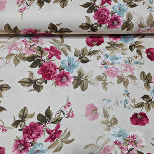Floral upholstery fabric with fuchsia pink and blue flowers and sage green leaves on a white background.