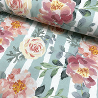Shabby chic upholstery curtain fabric patterned with pink flowers, yellow roses and green leaves on a duck egg background.
