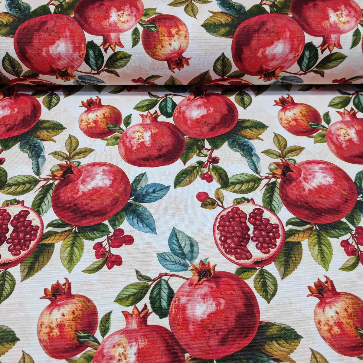 Upholstery curtain fabric patterned with bright red pomegranates and green leaves on a white background.