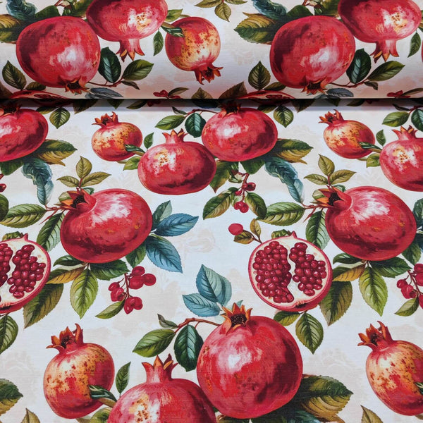 Upholstery curtain fabric patterned with bright red pomegranates and green leaves on a white background.
