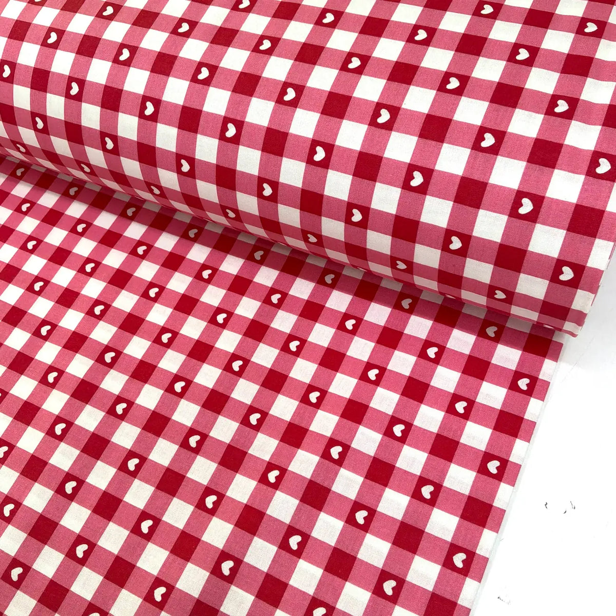 Red and white gingham 100% cotton fabric with small white heart print, ideal for quilting, sewing, dressmaking, patchwork, crafts and home décor.