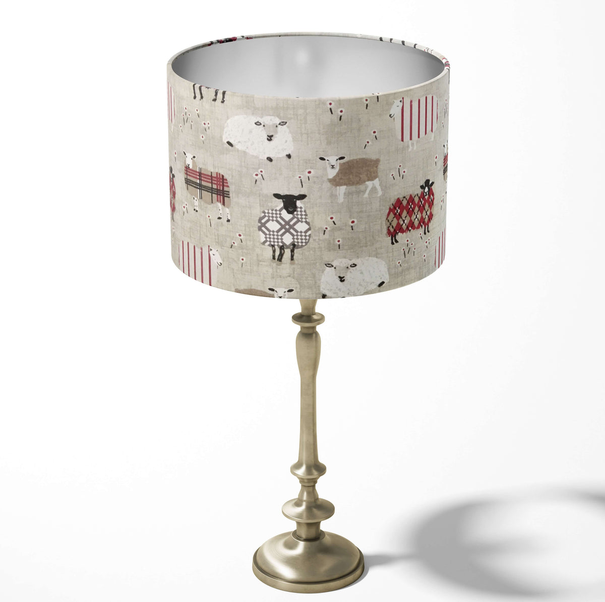 Decorative table lampshade featuring patchwork sheep patterns in grey, red and brown on a white background.
