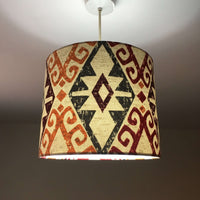 Decorative ceiling pendant with a geometric southwestern pattern on a plain background.