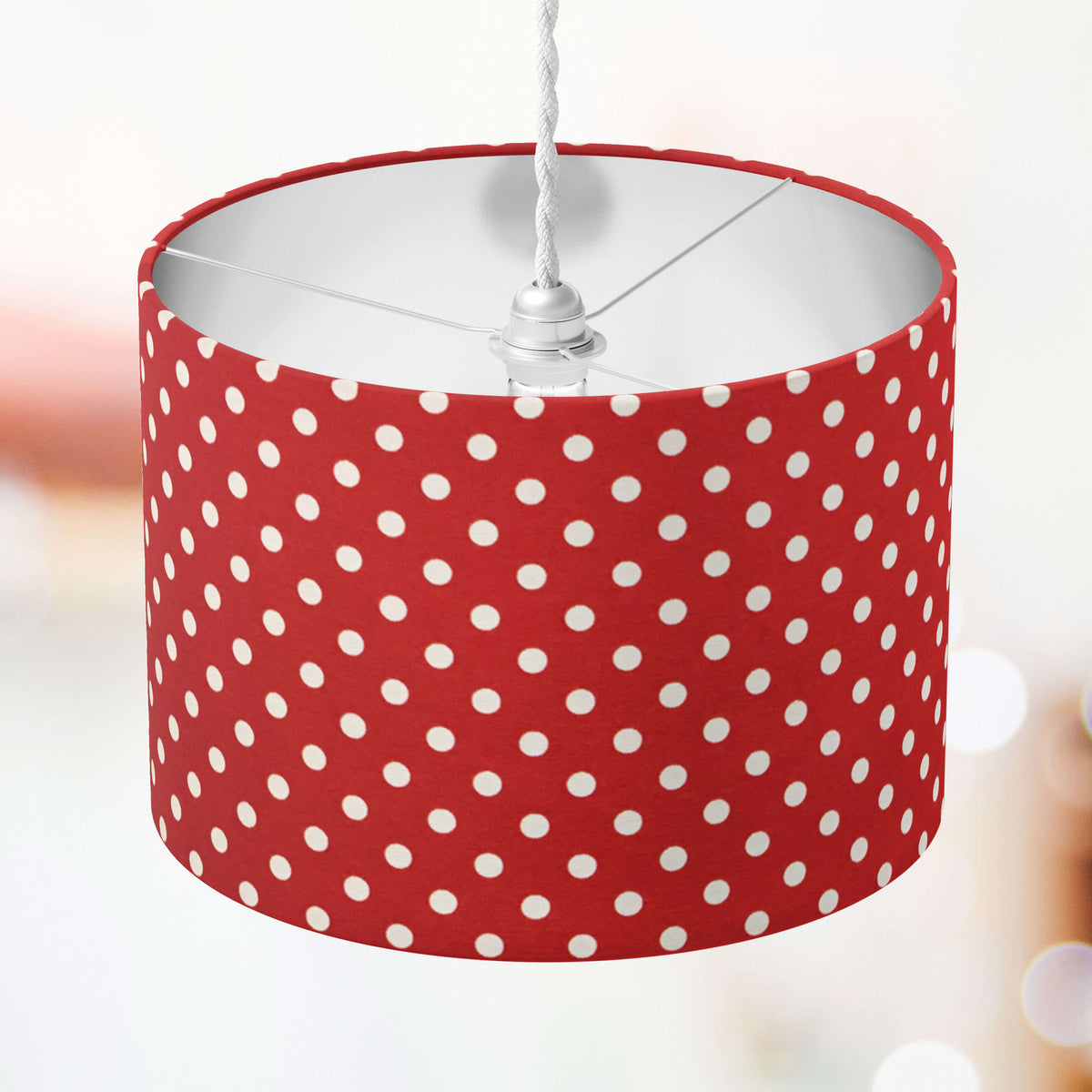 Red lampshade with white polka dots on a blurred background.