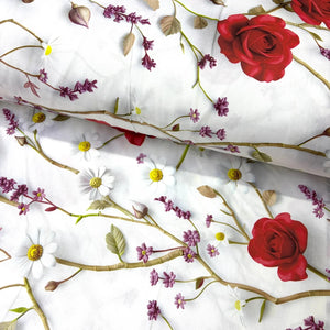 White cotton poplin fabric with a detailed floral print featuring red roses, white daisies, purple blossoms, and green leaves.