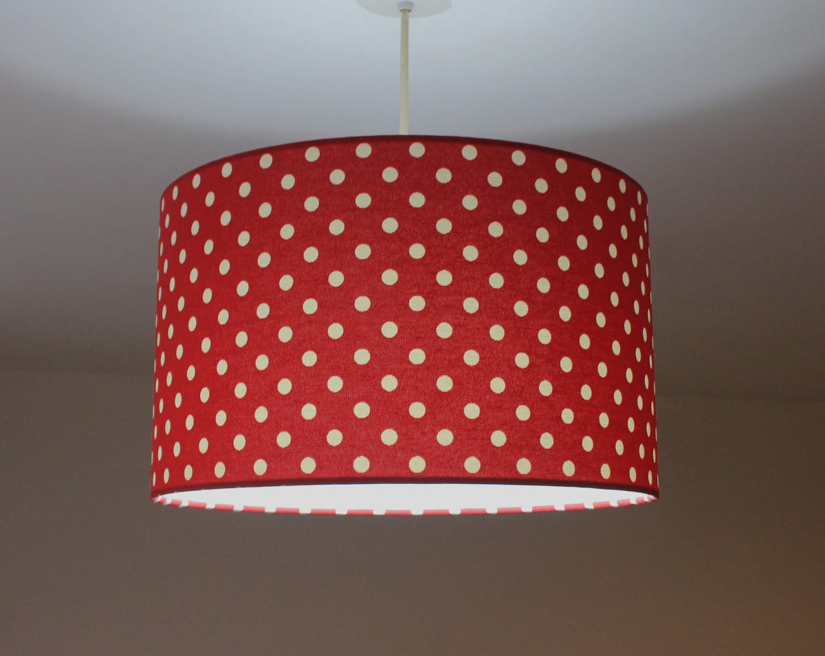 Retro red and white polka dot ceiling lampshade on a plain background.