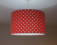 Retro red and white polka dot ceiling lampshade on a plain background.