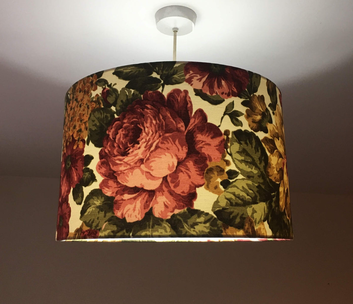 Floral patterned lampshade hanging from a ceiling light fixture.