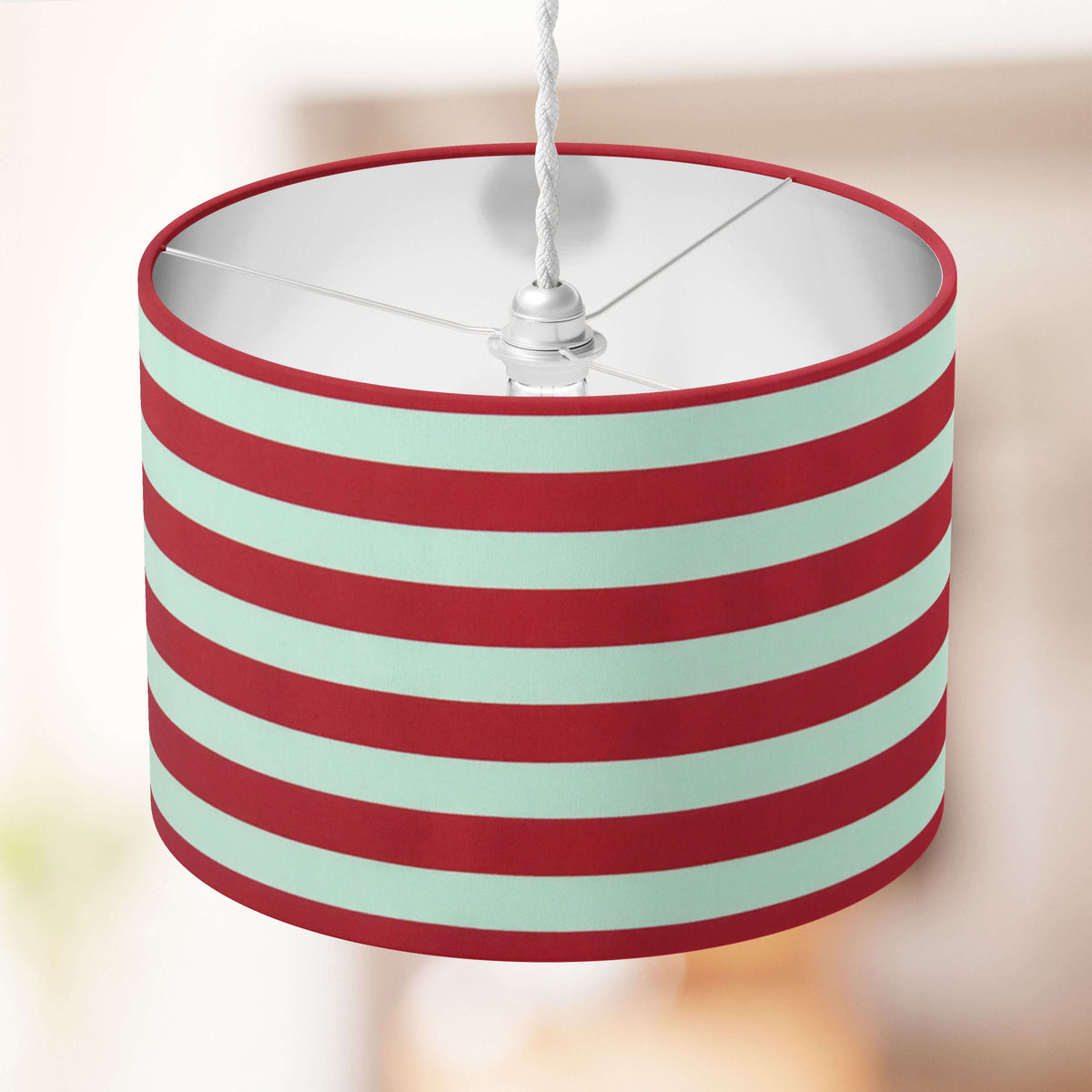 Striped lampshade with red and white horizontal stripes on a blurred background.