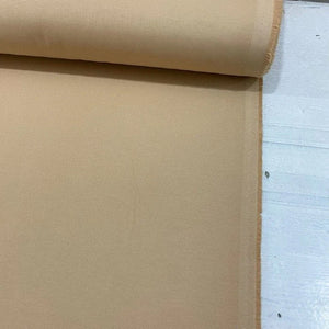 Sand beige cotton canvas fabric with a durable plain woven texture, ideal for upholstery, curtains, cushions, bags and craft projects.
