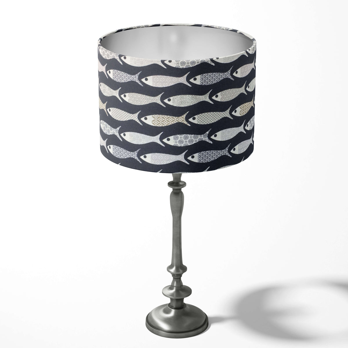 Navy blue table lampshade with grey fish-pattern on a white background.